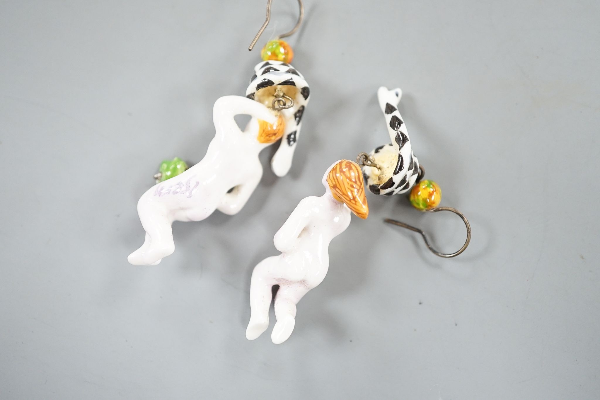 A pair of painted porcelain 'Adam & Eve with serpent' drop earrings, 62mm